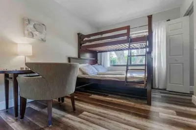 a bedroom with a bunk bed with a desk and a chair at Charming house Miami in Miami