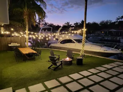 a yard with a table and a boat with lights at Waterfront - Kayak & Paddleboards - Firepit - Pool in Miami