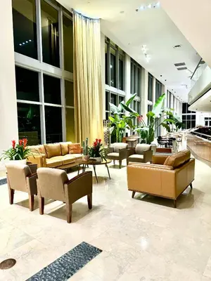a large lobby with couches and tables and windows at Marena Resort in Sunny Isles Beach
