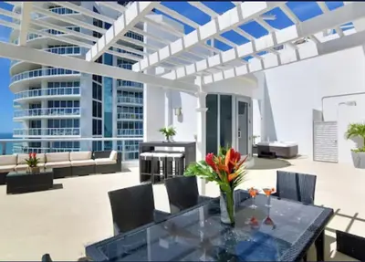 a patio with a table and chairs and a building at Marena Resort in Sunny Isles Beach