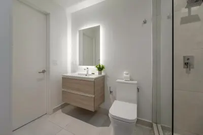 a bathroom with a toilet and a sink and a mirror at Condo with Amazing Views in the Heart of Brickell in Miami