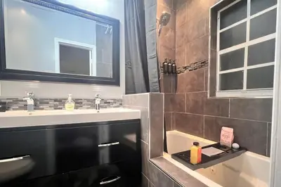 a bathroom with a sink and a shower with a mirror at King Bed, 3 miles to Stadium in Miami Gardens