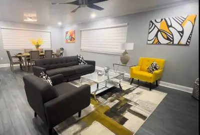 a living room with couches and a yellow chair at King Bed, 3 miles to Stadium in Miami Gardens
