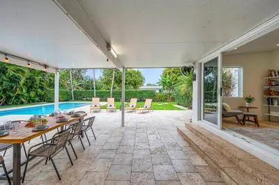 an indoor patio with a table and chairs and a swimming pool at Samadhi - NEW 15 min drive to Ultra, by Newman Hospitality in Miami Shores