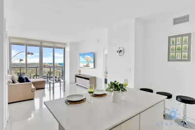 a kitchen and living room with a table and chairs at Breathtaking 31st Fl Beachwalk Penthouse View in Hallandale Beach