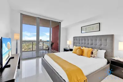 a bedroom with a king sized bed and a television at Breathtaking 31st Fl Beachwalk Penthouse View in Hallandale Beach
