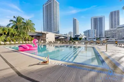 a large swimming pool with a city skyline in the background at Breathtaking 31st Fl Beachwalk Penthouse View in Hallandale Beach