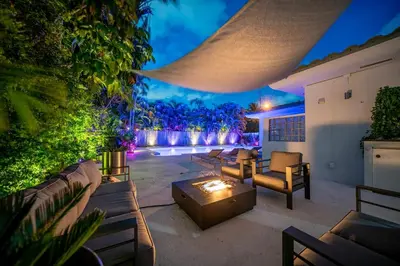 a backyard patio with couches and a fire pit at New Luxury Villa Delilah Biscayne Park in Biscayne Park