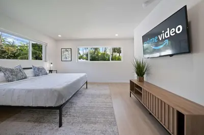 a bedroom with a large bed and a tv on the wall at New Luxury Villa Delilah Biscayne Park in Biscayne Park