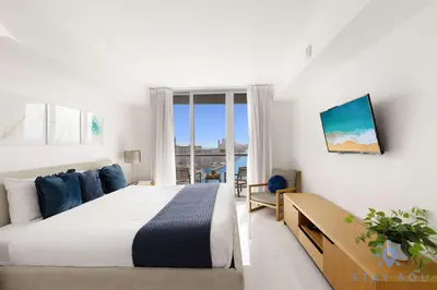 a white bedroom with a bed and a window at Spectacular Balcony View Retreat Resort Amenities in Hallandale Beach