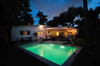 a swimming pool in front of a house at night at Pool! Best location! Steps to the water! Kid friendly! in Miami