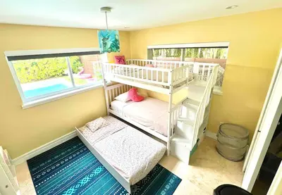 a small room with two bunk beds and a window at Pool! Best location! Steps to the water! Kid friendly! in Miami