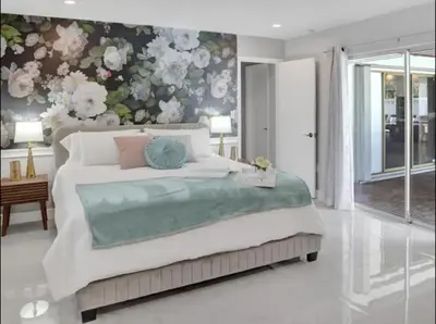 a bedroom with a large bed with a floral wall at Modern 4 Bedroom -Kosher - Heated Pool - Game Room in Hollywood