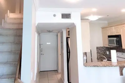 a hallway of a house with a kitchen and a door at Miami Beach Apartments by MiaRentals in Miami Beach
