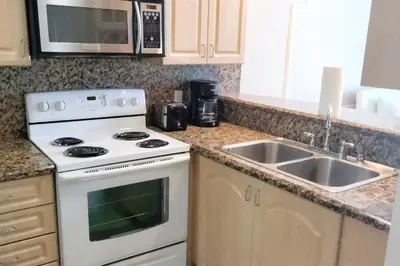 a kitchen with a white stove and a sink at Miami Beach Apartments by MiaRentals in Miami Beach