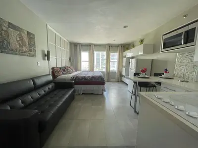 a living room with a couch and a bed and a kitchen at Oceanfront Miami Beach Studio 925 in Miami Beach