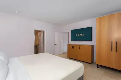 a bedroom with a bed and a tv on a wall at Roami at Hotel Astor in Miami Beach