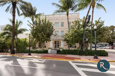 an empty street in front of a building with palm trees at Roami at Hotel Astor in Miami Beach