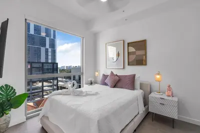 a bedroom with a white bed and a large window at Miami Magic Vibrant 2 Bedroom with Free Parking in Miami