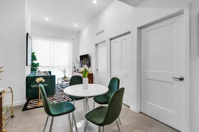 a living room with a table and green chairs at Miami Magic Vibrant 2 Bedroom with Free Parking in Miami