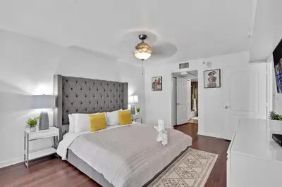 a white bedroom with a large bed with yellow pillows at Amazing 1 Bed in Brickell key With FREE PKG in Miami