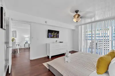a white bedroom with a bed and a white dresser at Amazing 1 Bed in Brickell key With FREE PKG in Miami