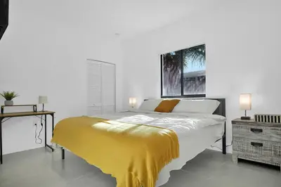 a bedroom with a bed with a yellow blanket on it at Villa 2 in Miami in Miami