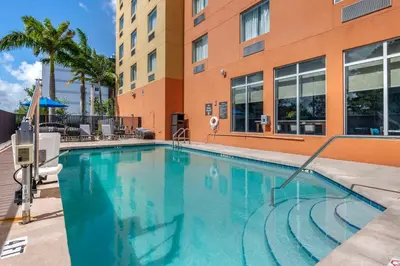 a large swimming pool in front of a building at Comfort Suites Fort Lauderdale Airport South & Cruise Port in Dania Beach