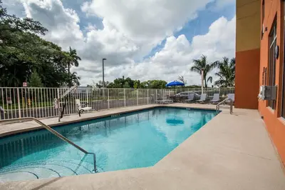 a swimming pool at a resort with at Comfort Suites Fort Lauderdale Airport South & Cruise Port in Dania Beach