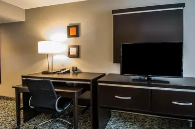a room with a desk with a television and a chair at Comfort Suites Fort Lauderdale Airport South & Cruise Port in Dania Beach
