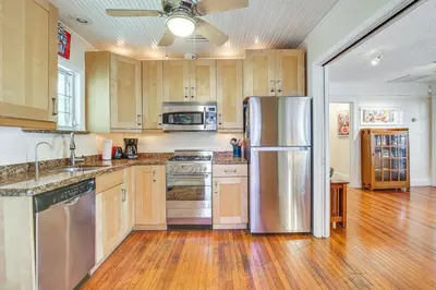 a kitchen with a stainless steel refrigerator and wooden cabinets at Fort Lauderdale Oasis with Pool about 2 Mi to Beach! in Fort Lauderdale