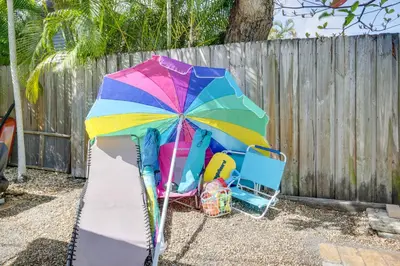a colorful umbrella sitting next to a chair and a fence at Fort Lauderdale Oasis with Pool about 2 Mi to Beach! in Fort Lauderdale