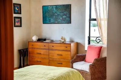 a bedroom with a dresser and a chair next to a window at The Netherland by MIAMI BEACH OCEAN RENTAL in Miami Beach