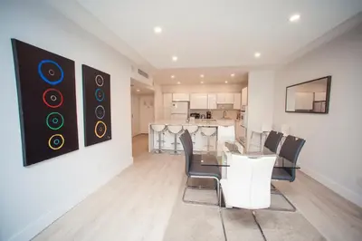 a dining room with a table and chairs and a kitchen at Comfortable and broad apartment in O-Reserve near on the beach in Sunny Isles Beach