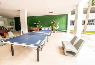 a room with a ping pong table and chairs at Comfortable and broad apartment in O-Reserve near on the beach in Sunny Isles Beach