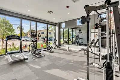 a gym with several bikes in a room with windows at Ocean Wave Deluxe Brand New Apartments in Fort Lauderdale