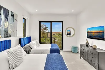 a bedroom with two beds and a window at Ocean Wave Deluxe Brand New Apartments in Fort Lauderdale