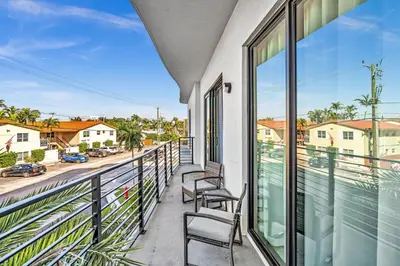 a balcony with chairs and a view of a street at Ocean Wave Deluxe Brand New Apartments in Fort Lauderdale
