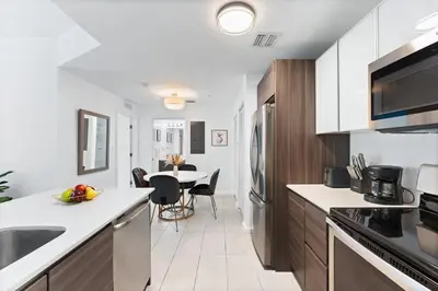a kitchen with white countertops and a dining room at Modern apartment in Edgewater in Miami