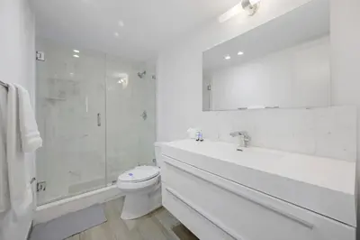 a white bathroom with a toilet and a shower at Spacious apartment of 2BR - 2BTH in Ocean Reserv front the beach in Sunny Isles Beach