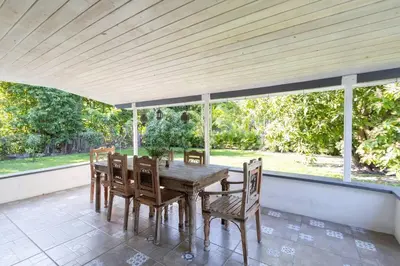 a wooden table and chairs on a porch with windows at Tropical Private Oasis Mins from Beach & Downtown in Miami