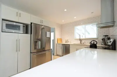 a kitchen with a stainless steel refrigerator and white cabinets at Tropical Private Oasis Mins from Beach & Downtown in Miami