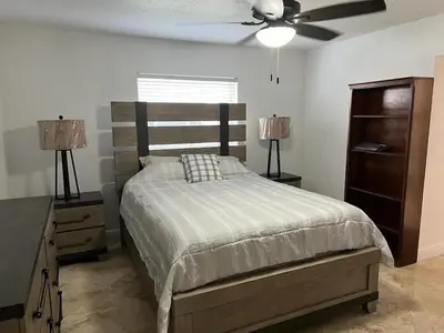 a bedroom with a bed and a ceiling fan at Cozy lakeside suite with private bath & entrance in Pembroke Pines