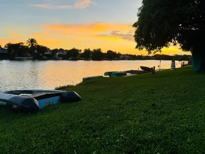 a boat sitting on the grass next to a lake at Cozy lakeside suite with private bath & entrance in Pembroke Pines