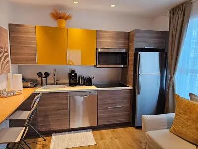 a kitchen with a stainless steel refrigerator and wooden cabinets at Bright 1BedRoom RENOVATED NEAR THE BEACH (4PPL) in Miami Beach