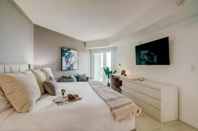 a bedroom with a large white bed and a desk at Direct Bayview One Bedroom Condo in Coconut Grove Includes parking in Miami