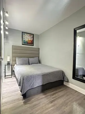 a bedroom with a bed and a mirror at Sheridan Suites Apartments in Dania Beach