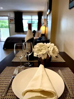 a table with a plate and a vase with flowers on it at Sheridan Suites Apartments in Dania Beach