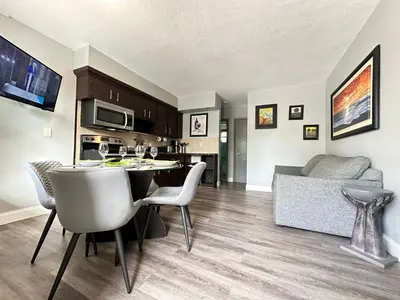 a kitchen and living room with a table and chairs at Sheridan Suites Apartments in Dania Beach
