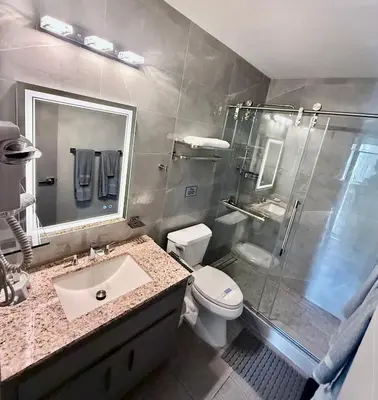 a bathroom with a shower and a sink and a toilet at Sheridan Suites Apartments in Dania Beach